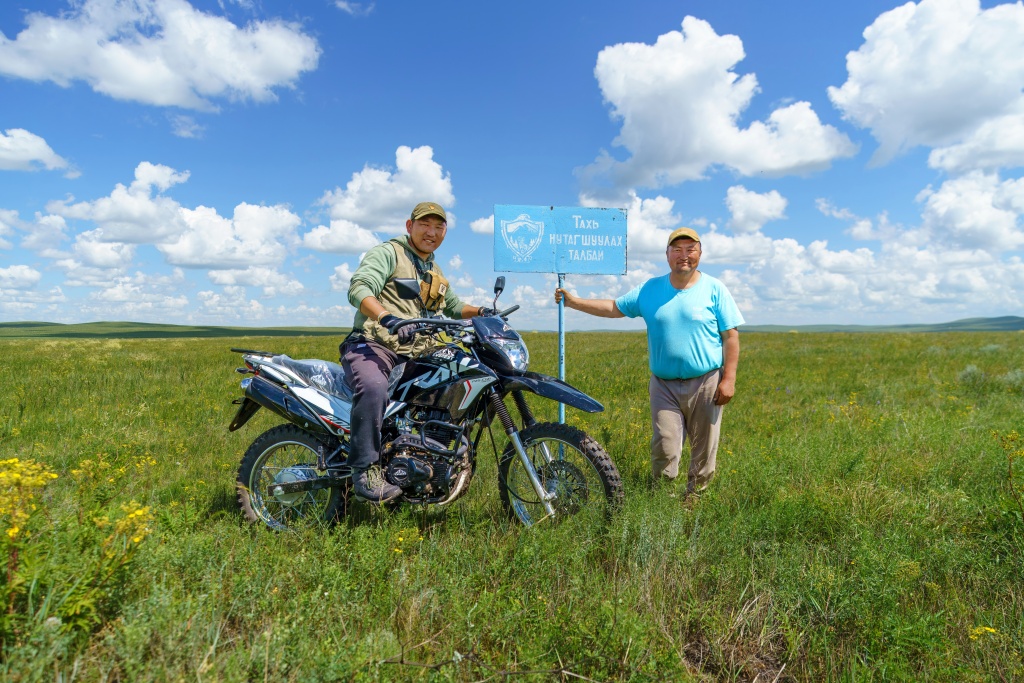 Dalaitseren and Ganbaatar on the edge of the Valley of Monasteries, by the sign stating that Przewalski’s horses will return to this area. Photo: David Broda